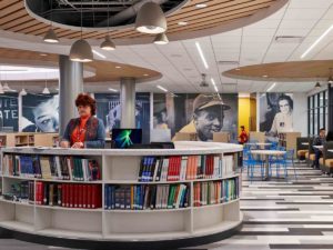 The library. It is vibrant and modern. Murals of Jackie Robinson and Maya Angelou in the distance.